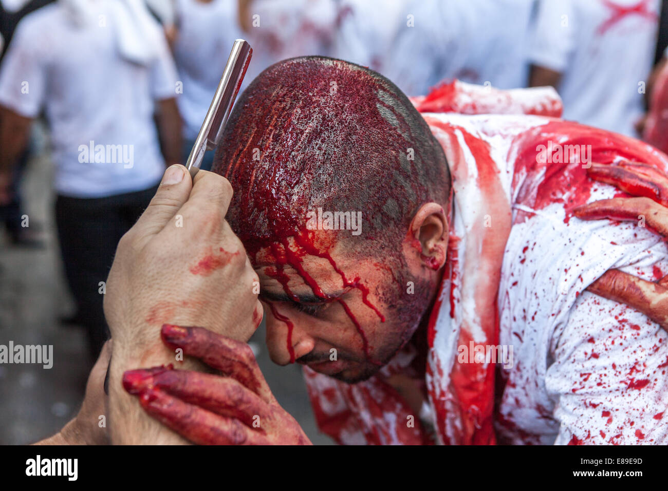 Un homme musulman chiite couvert de son propre sang a son front en chute de un rasoir au cours de la journée d'Ashoura à Nabatieh, Liban. Banque D'Images