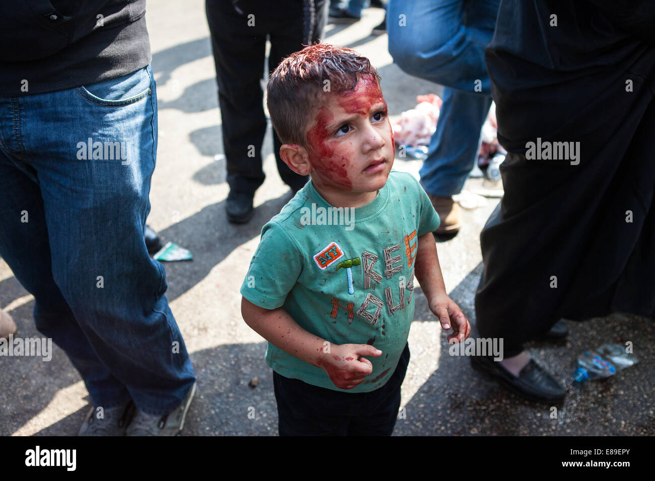 Un jeune garçon musulman chiite, son visage maculé de sang, à la recherche jusqu'à son père, au cours de la journée d'Ashoura, Nabatieh, Liban. Banque D'Images