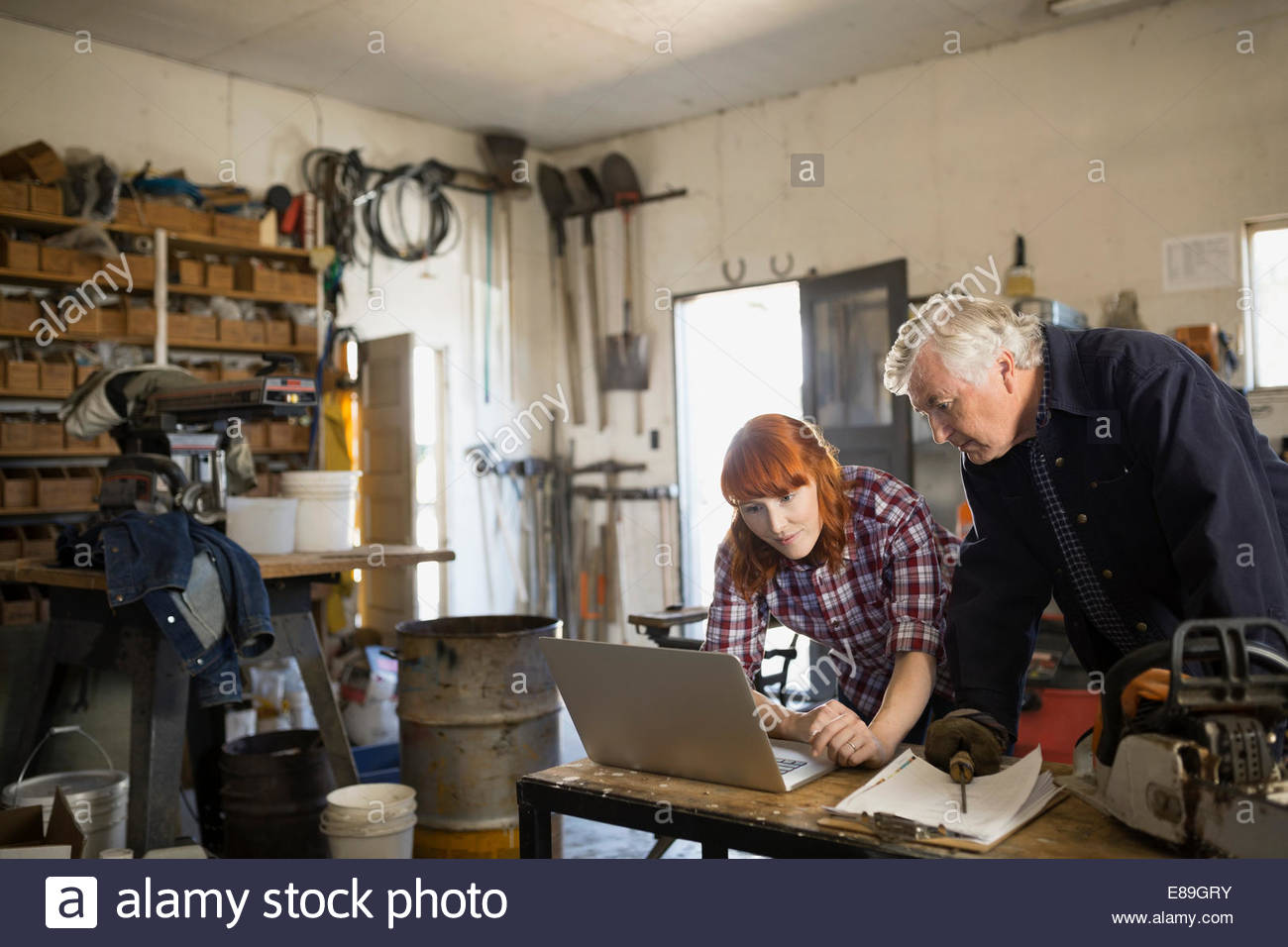 Père et fille working on laptop in workshop Banque D'Images