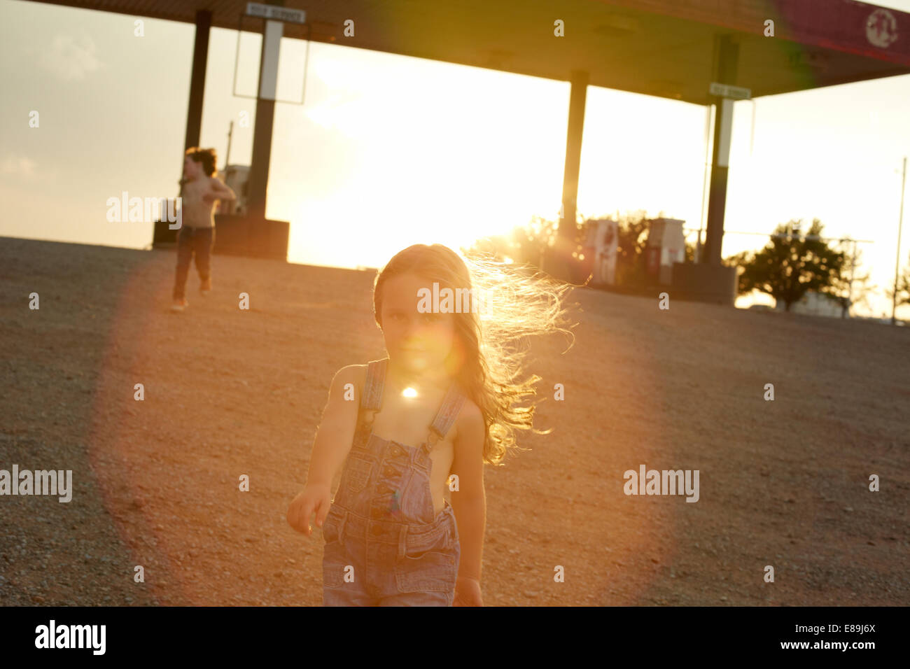 Enfants à la station d'essence au coucher du soleil Banque D'Images