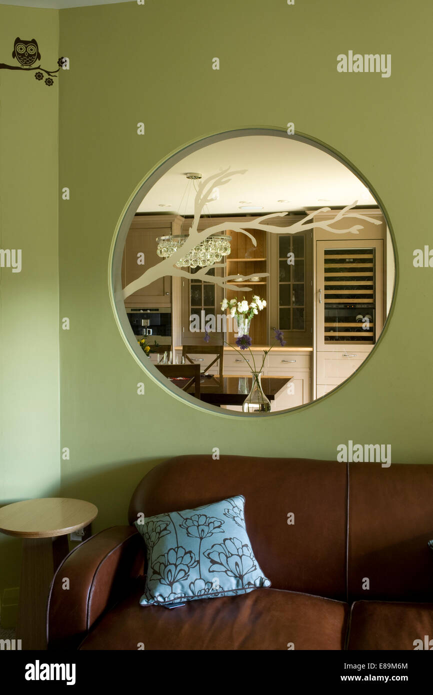 Hublot en verre gravé à l'intérieur fenêtre au-dessus d'un canapé en cuir  brun dans le salon vert Photo Stock - Alamy