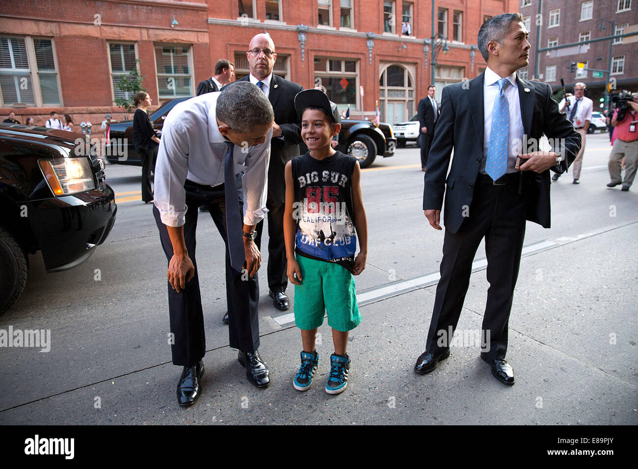 Les agents des services secrets américains accompagner le président Barack Obama, il accueille un jeune garçon sur la rue à Denver, Colorado, le 8 juillet 2014. Banque D'Images