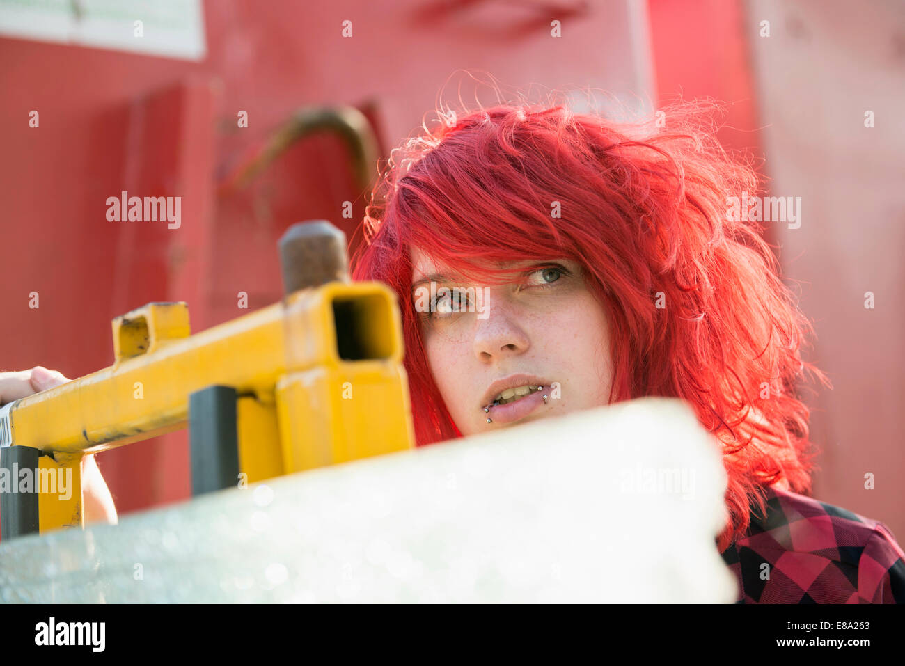 Jeune adolescente piercings cheveux teints en rouge Banque D'Images