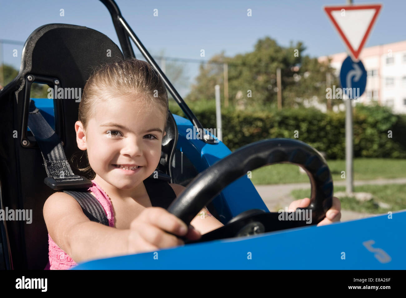 Smiling girl in véhicule sur la zone de formation de conducteur Banque D'Images