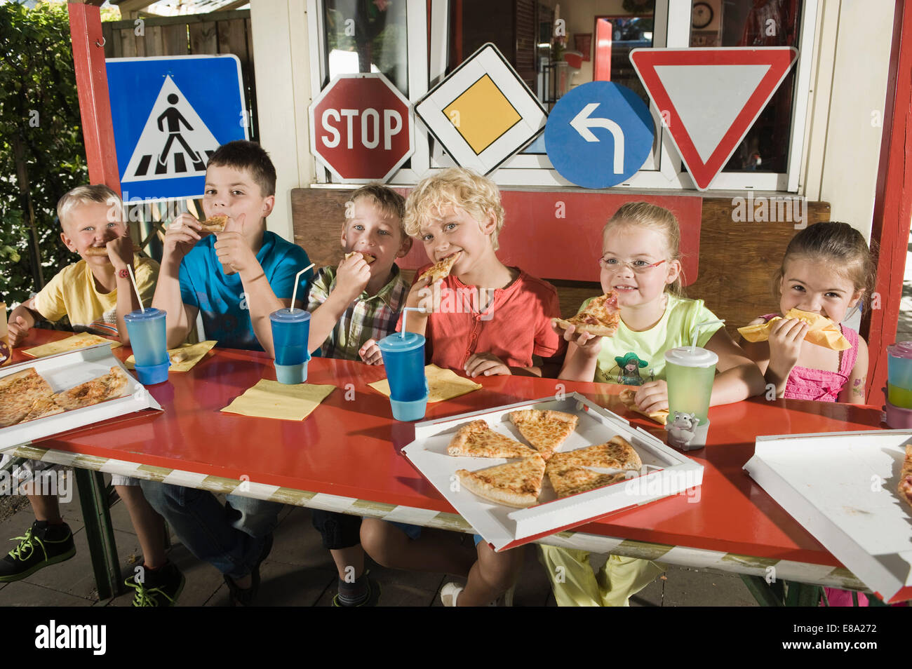 Les enfants de manger une pizza à la zone d'entraînement de pilote Banque D'Images