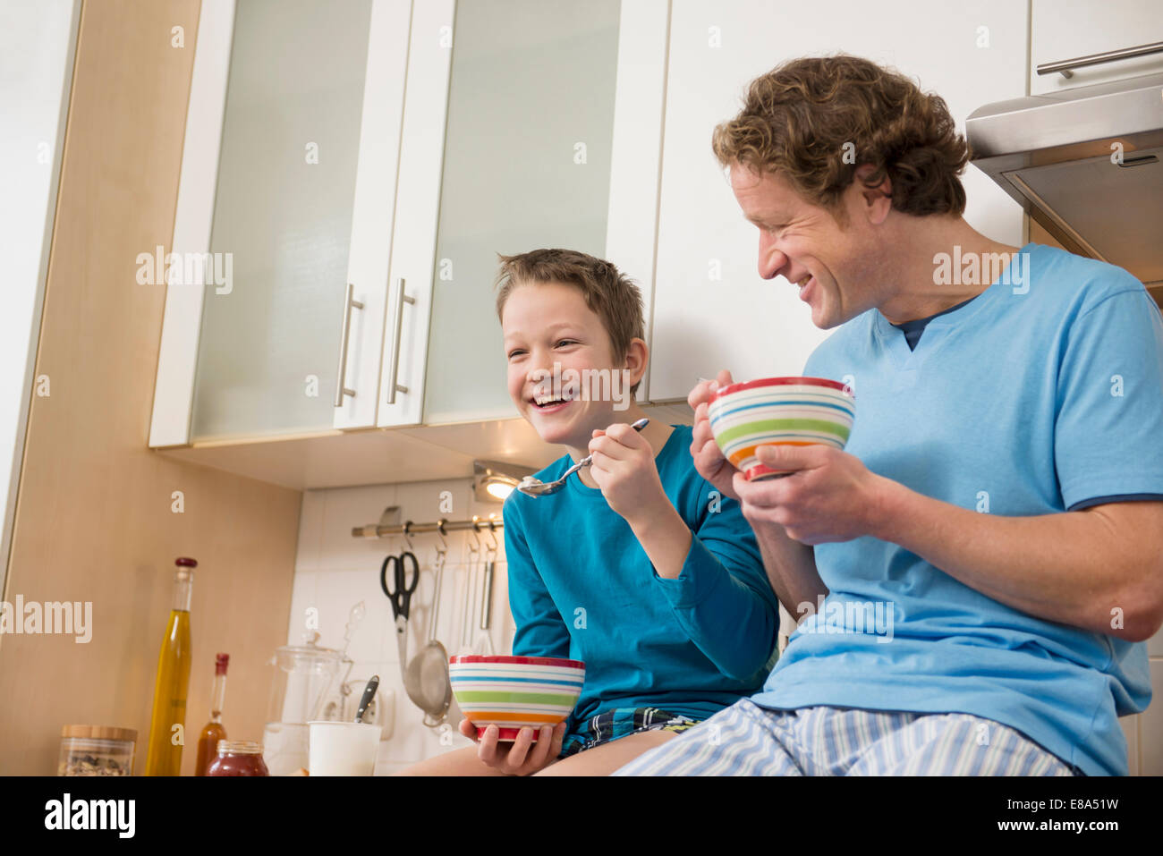 Père et fils de manger du muesli dans la cuisine Banque D'Images
