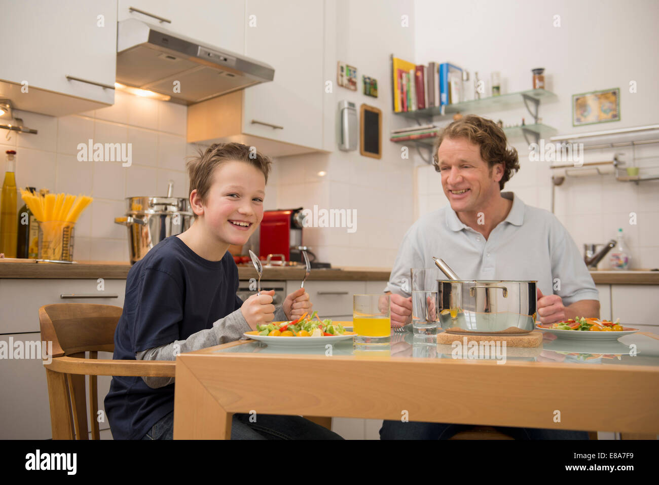 Père et fils de manger dans la cuisine Banque D'Images