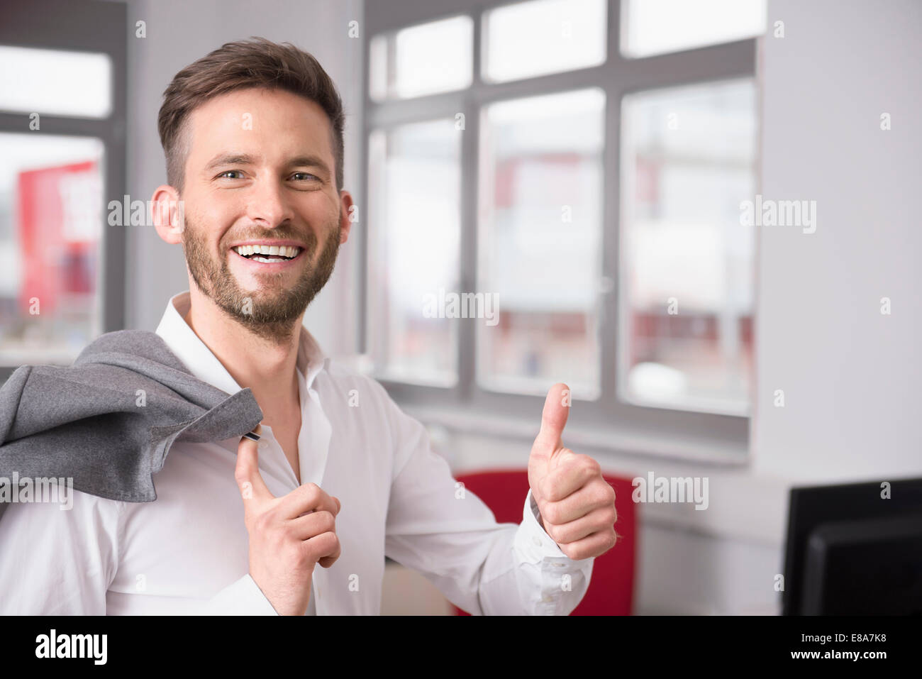 Jeune homme office Thumbs up sign smiling Banque D'Images