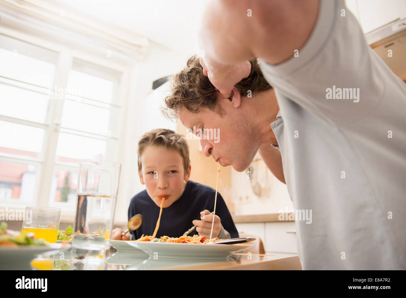 Père et fils mange du spaghetti dans la cuisine Banque D'Images