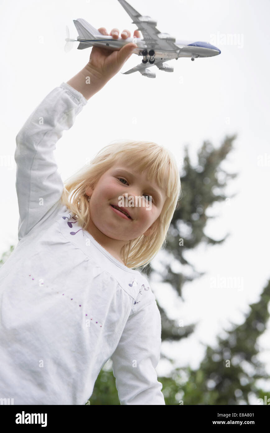 Petite blonde girl Playing with toy airplane Banque D'Images