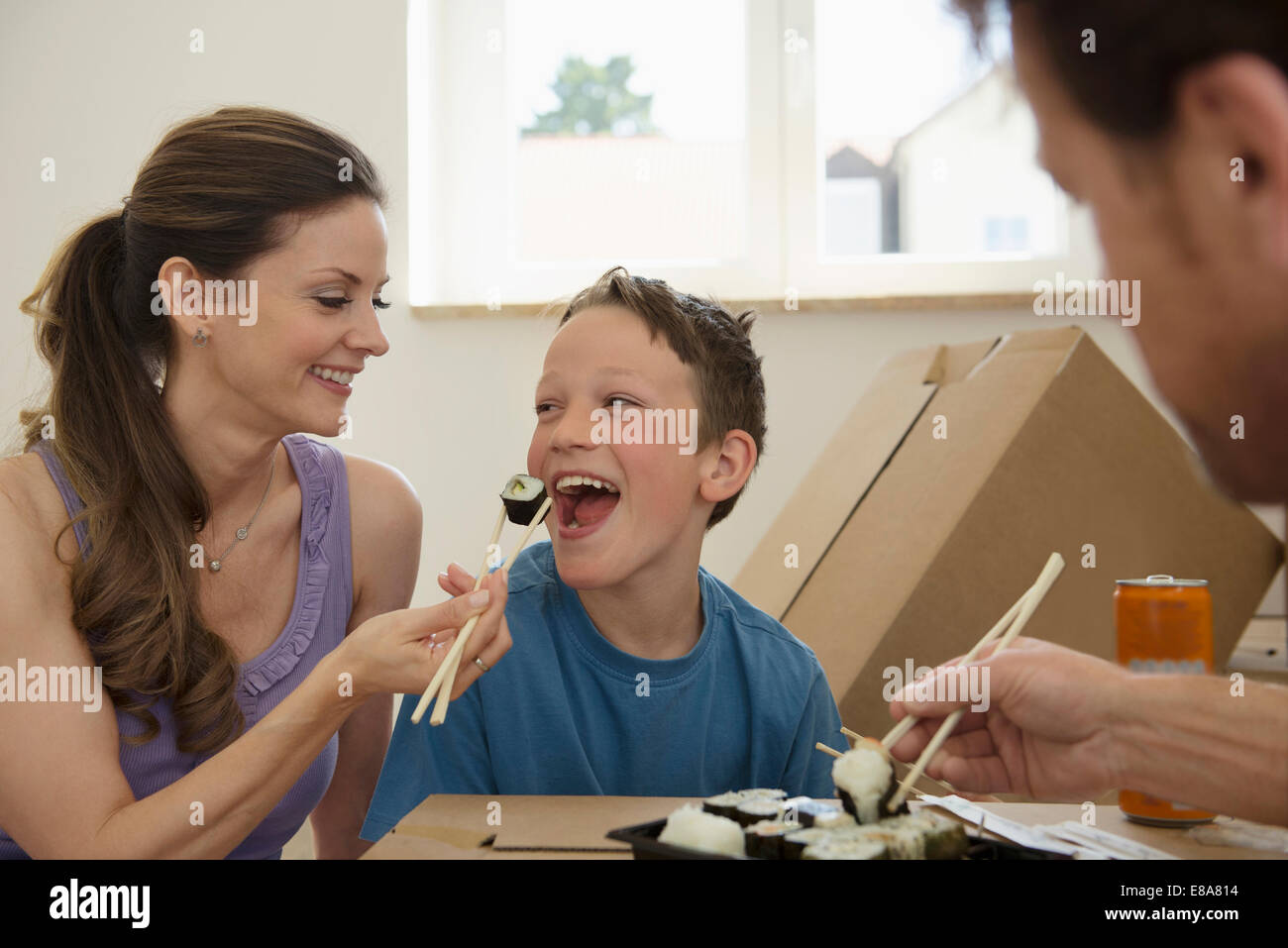 Nouvelle maison déménagement dans family eating sushi Banque D'Images