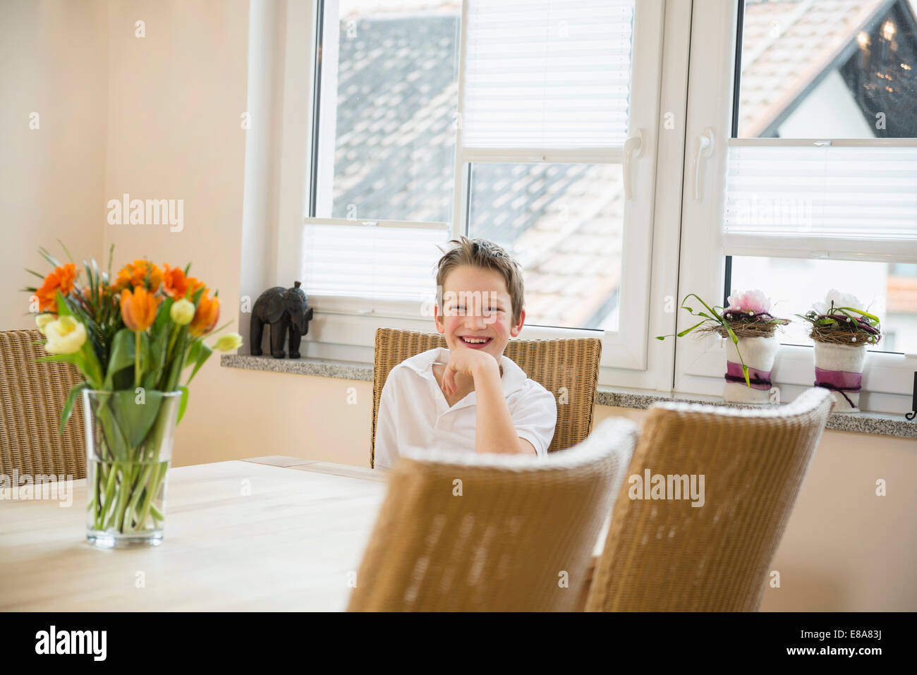 Portrait of smiling boy sitting at table Banque D'Images
