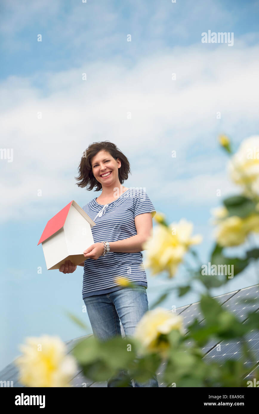 Woman holding model house roses l'énergie propre Banque D'Images