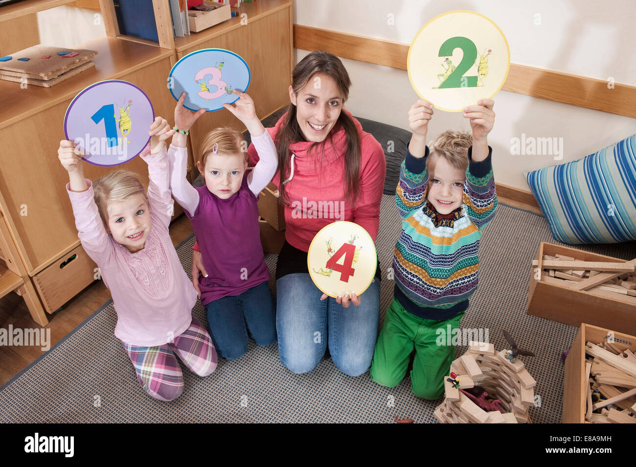 Photo de groupe des femmes d'éducateur et de trois enfants en maternelle Banque D'Images