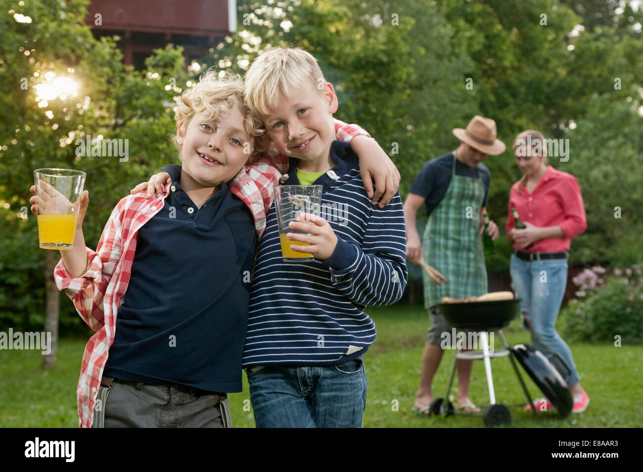 Barbecue familial parents amis garçons jardin Banque D'Images