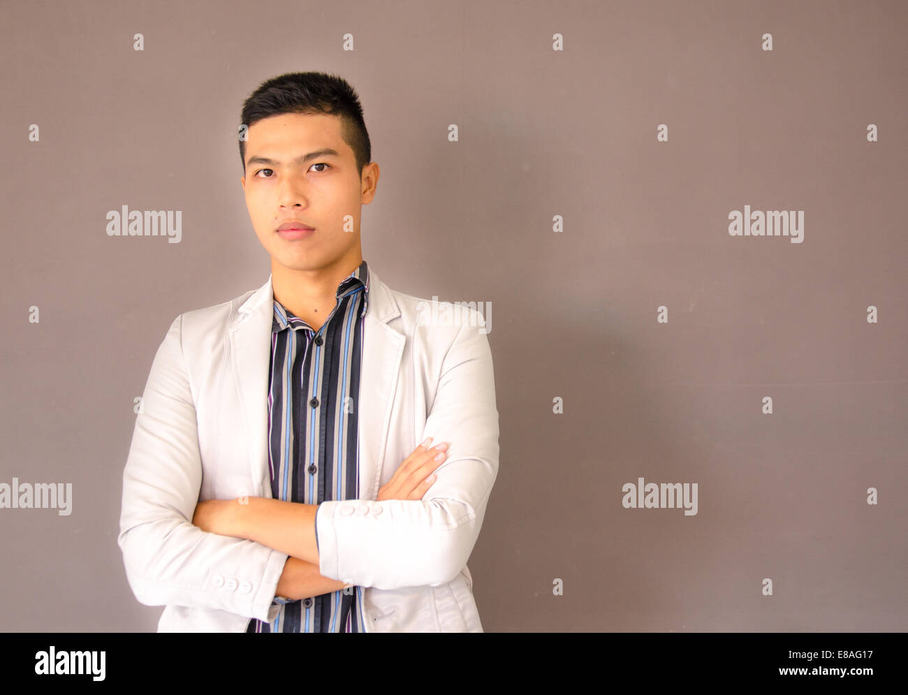 Young Asian business man sur fond brun Banque D'Images