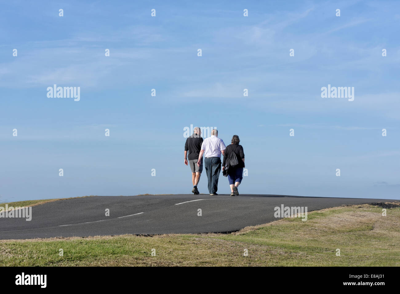 Trois personnes (2 hommes et une femme) à pied de la caméra le long d'un sentier du littoral à Blackpool, lancashire, uk Banque D'Images