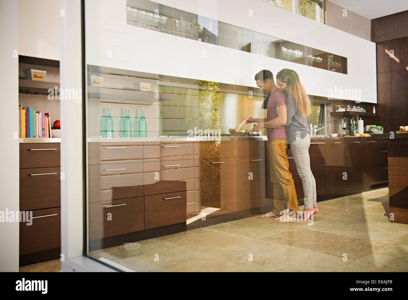 Aimé jusqu'couple cooking sur plaque de cuisson dans la cuisine Banque D'Images