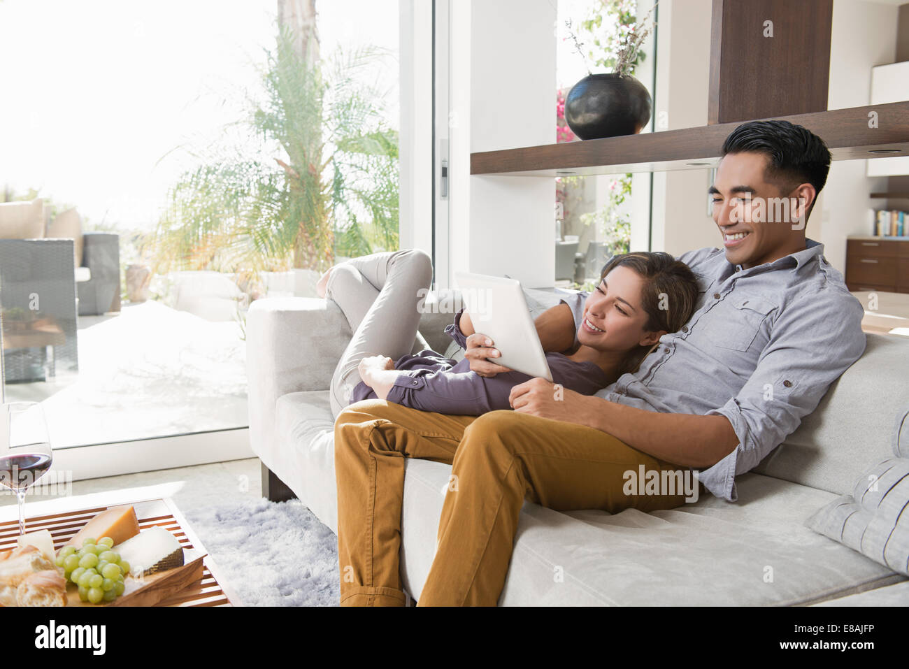 Couple sur salon canapé looking at digital tablet Banque D'Images