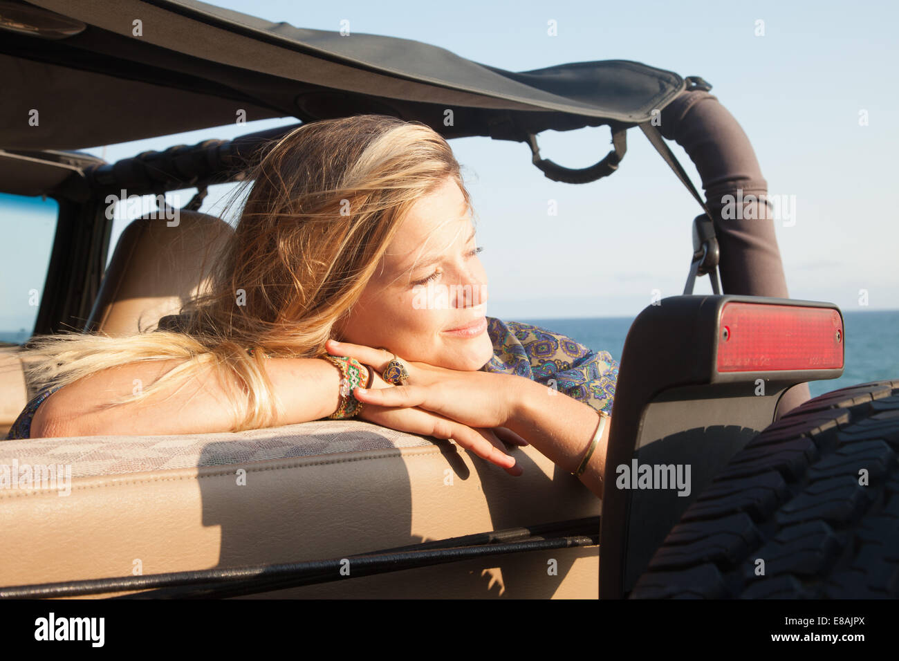 Young woman leaning on jeep fenêtre à l'autre, Malibu, California, USA Banque D'Images