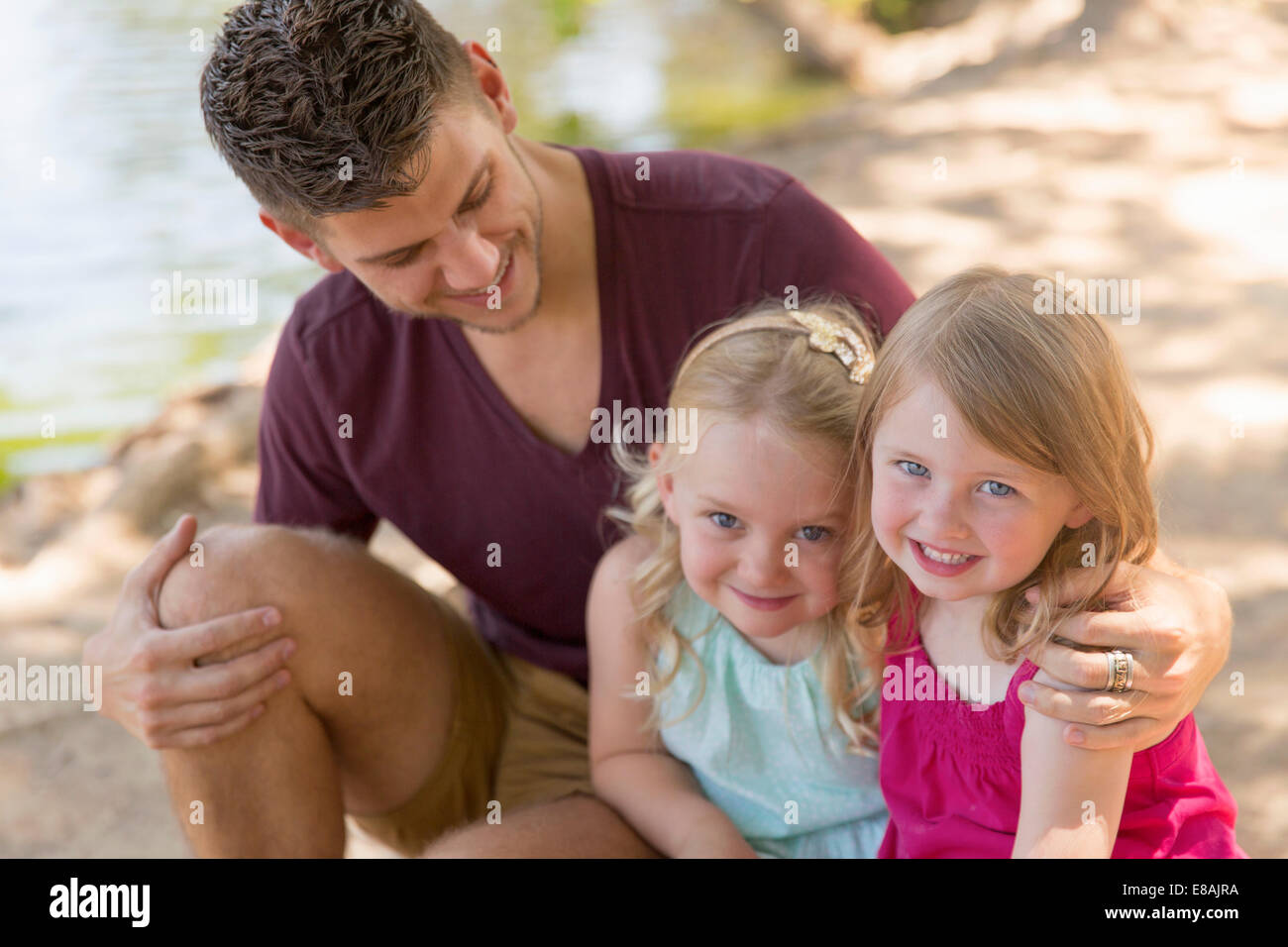 Portrait de père et deux filles on riverbank Banque D'Images