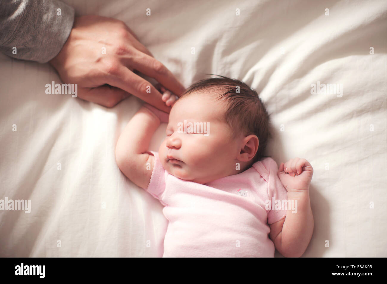 Baby Girl sleeping, mains tenues par le père Banque D'Images