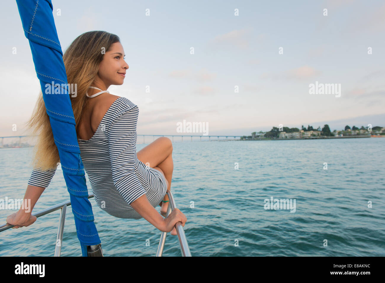 Mid adult woman sitting on main courante des bateau à voile Banque D'Images