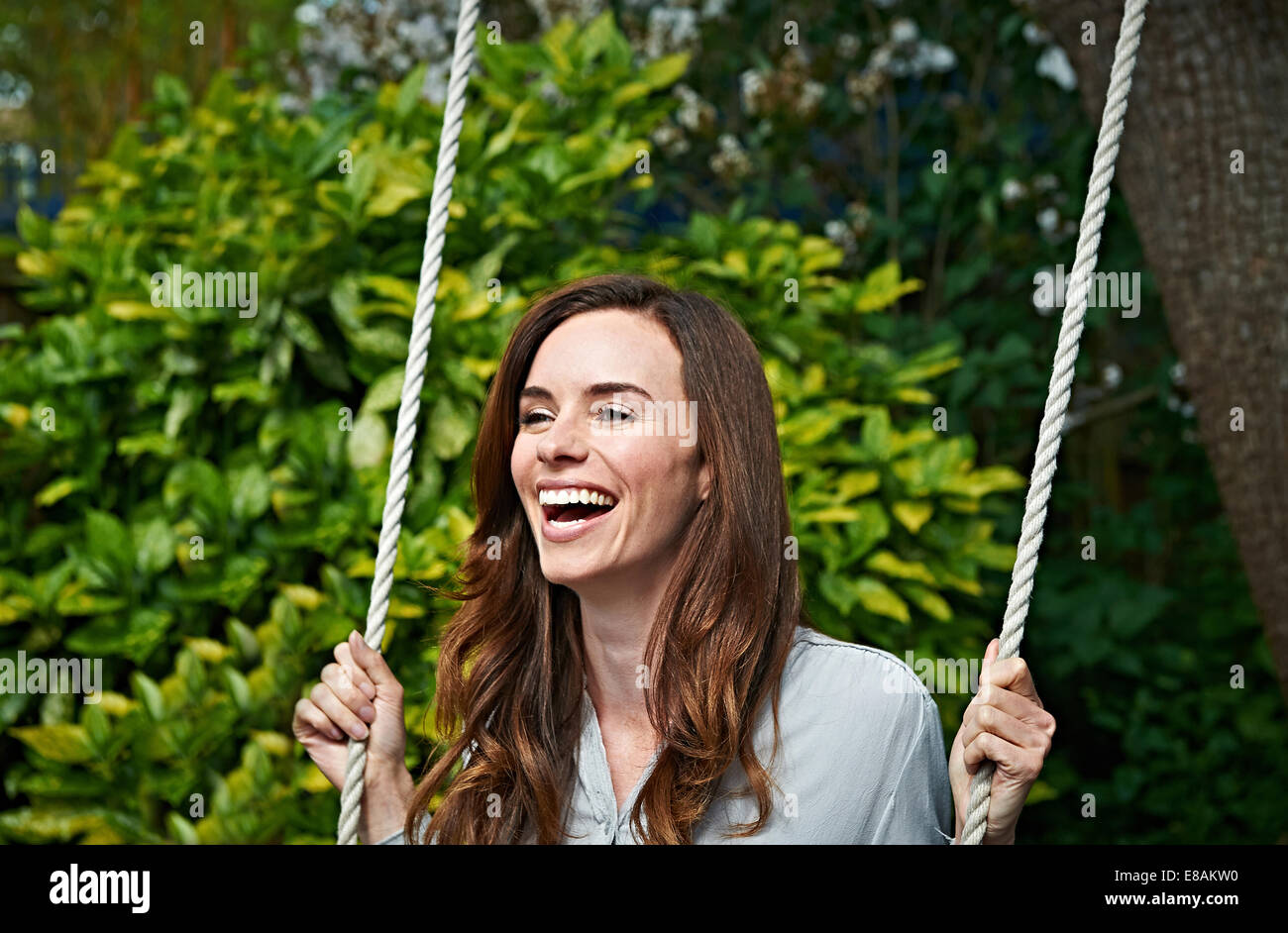 Woman laughing on swing Banque D'Images
