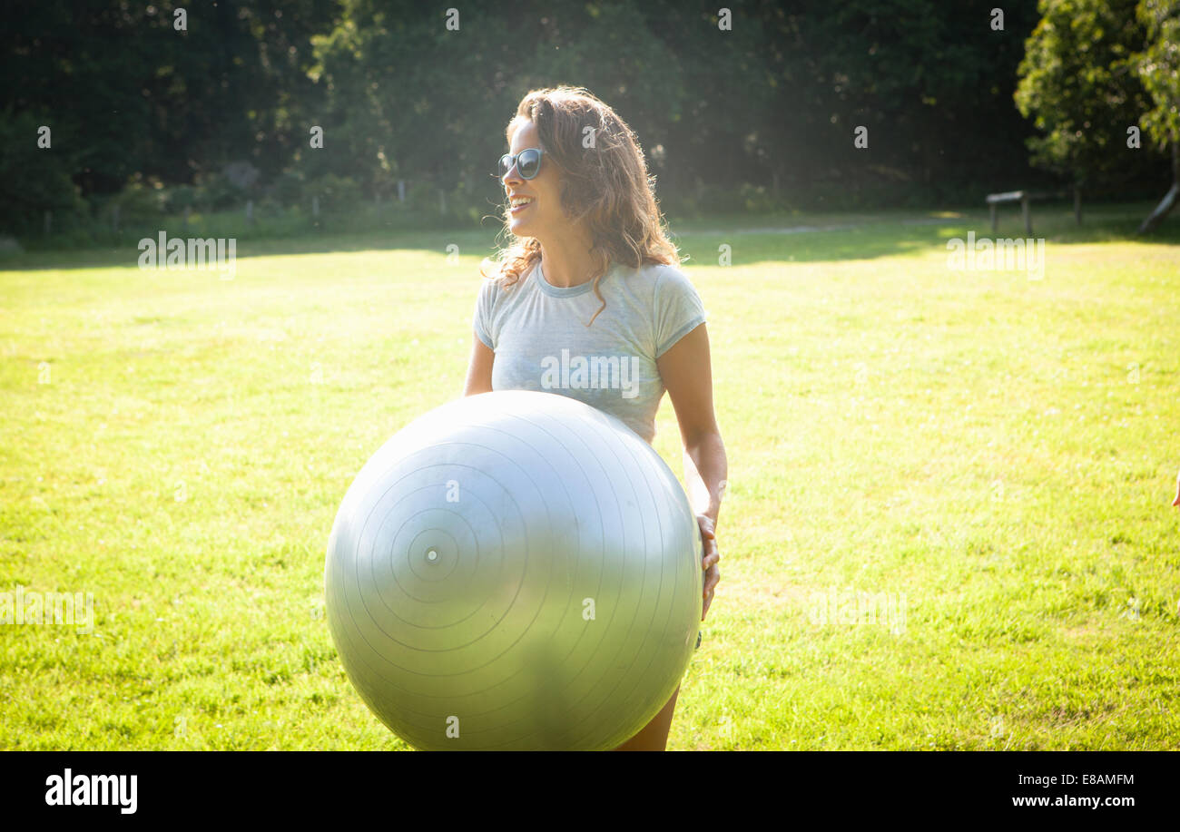 Mid adult woman holding up boule d'exercice dans le champ Banque D'Images