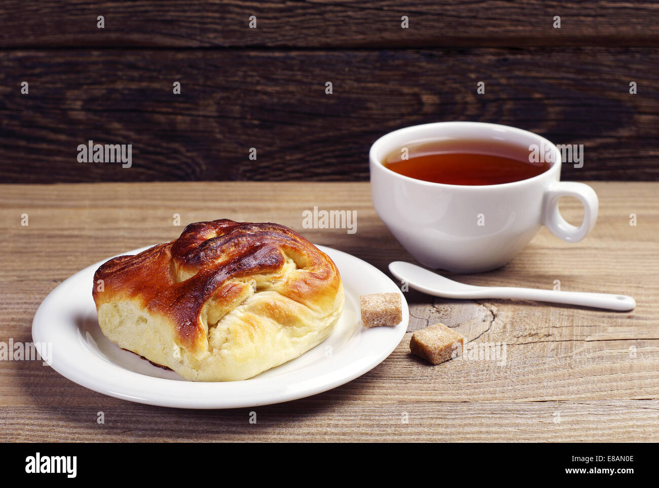 Délicieux pain et tasse de thé sur la table en bois Banque D'Images