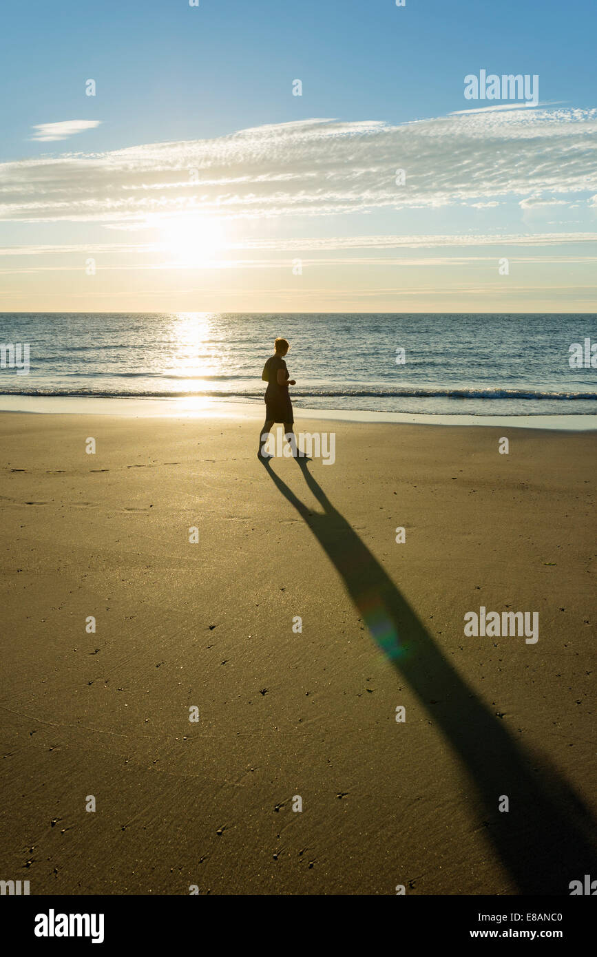 Mid adult woman strolling on beach at sunset, Westkapelle, Zélande, Pays-Bas Banque D'Images