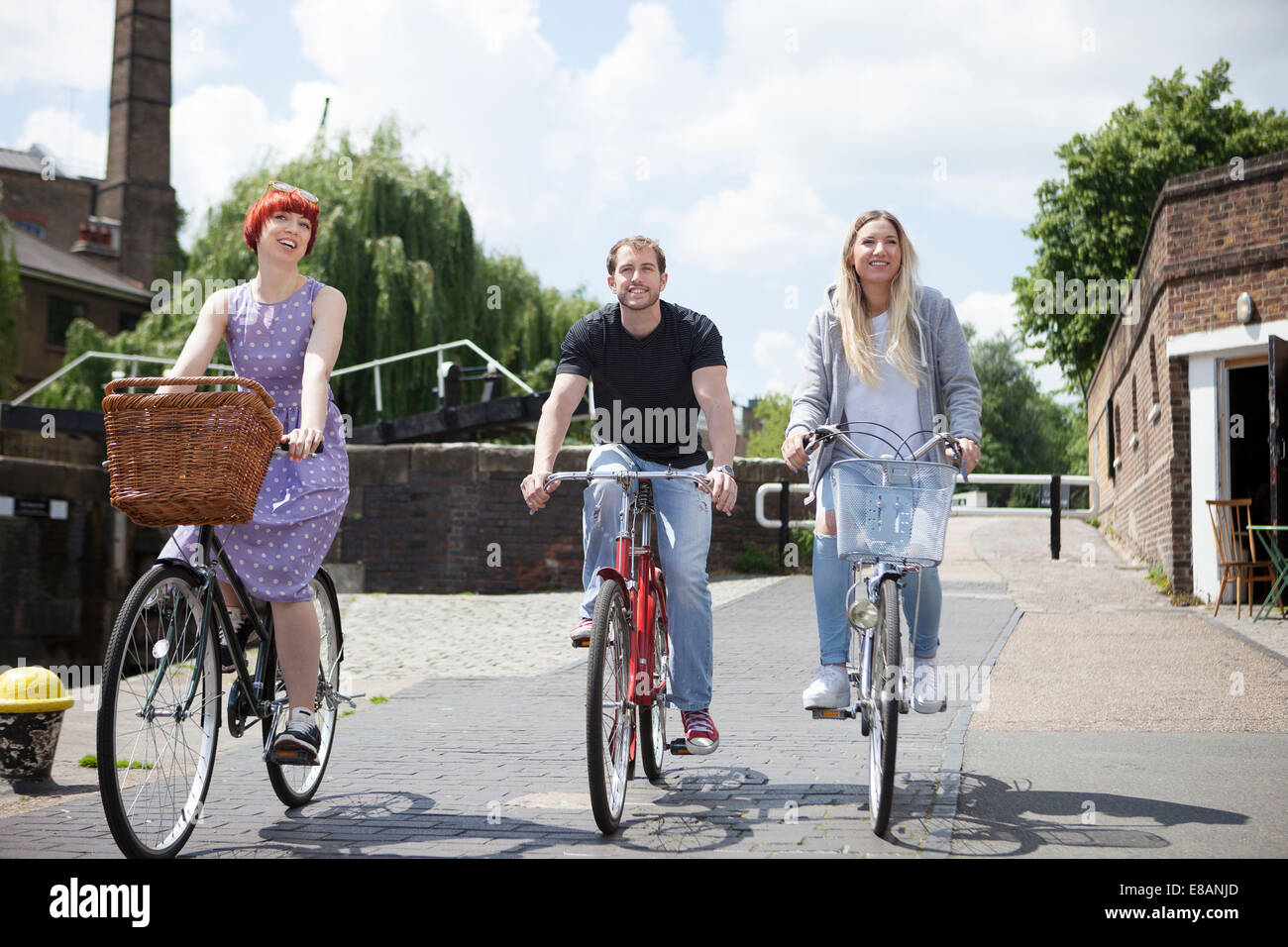 Friends riding bike le long de canal, East London, UK Banque D'Images