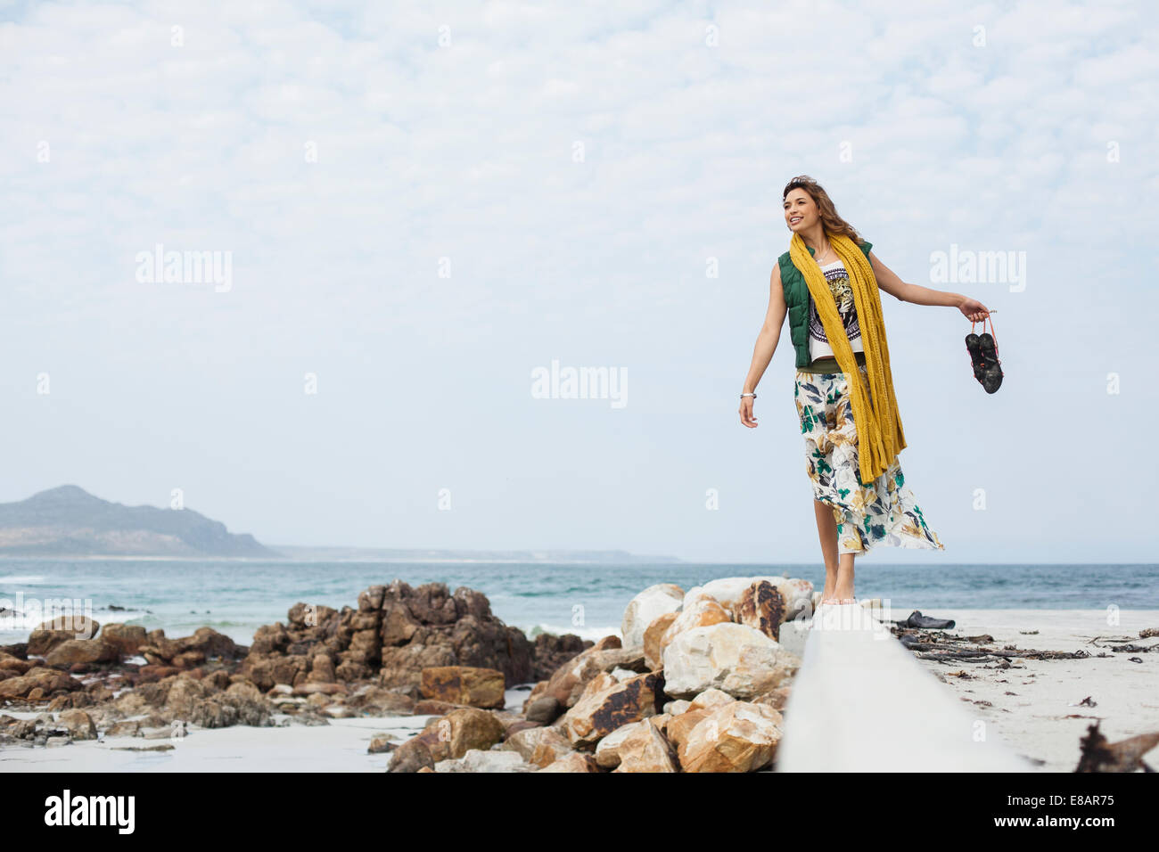 Jeune femme marche sur bloc de ciment on Beach, Cape Town, Western Cape, Afrique du Sud Banque D'Images