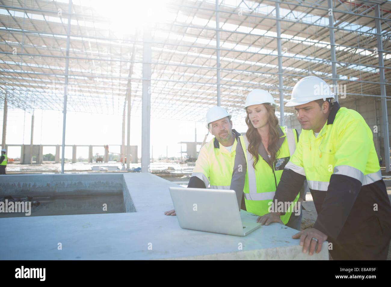 Les gestionnaires du site et l'architecte looking at laptop on construction site Banque D'Images