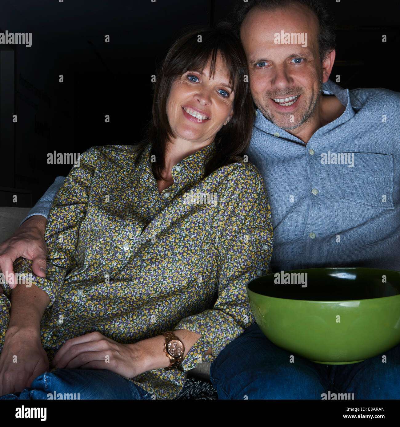 D'âge mûr regarder la TV avec snack-bol Banque D'Images