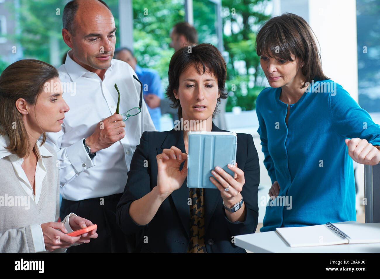 Des collègues d'affaires looking at digital tablet in office Banque D'Images