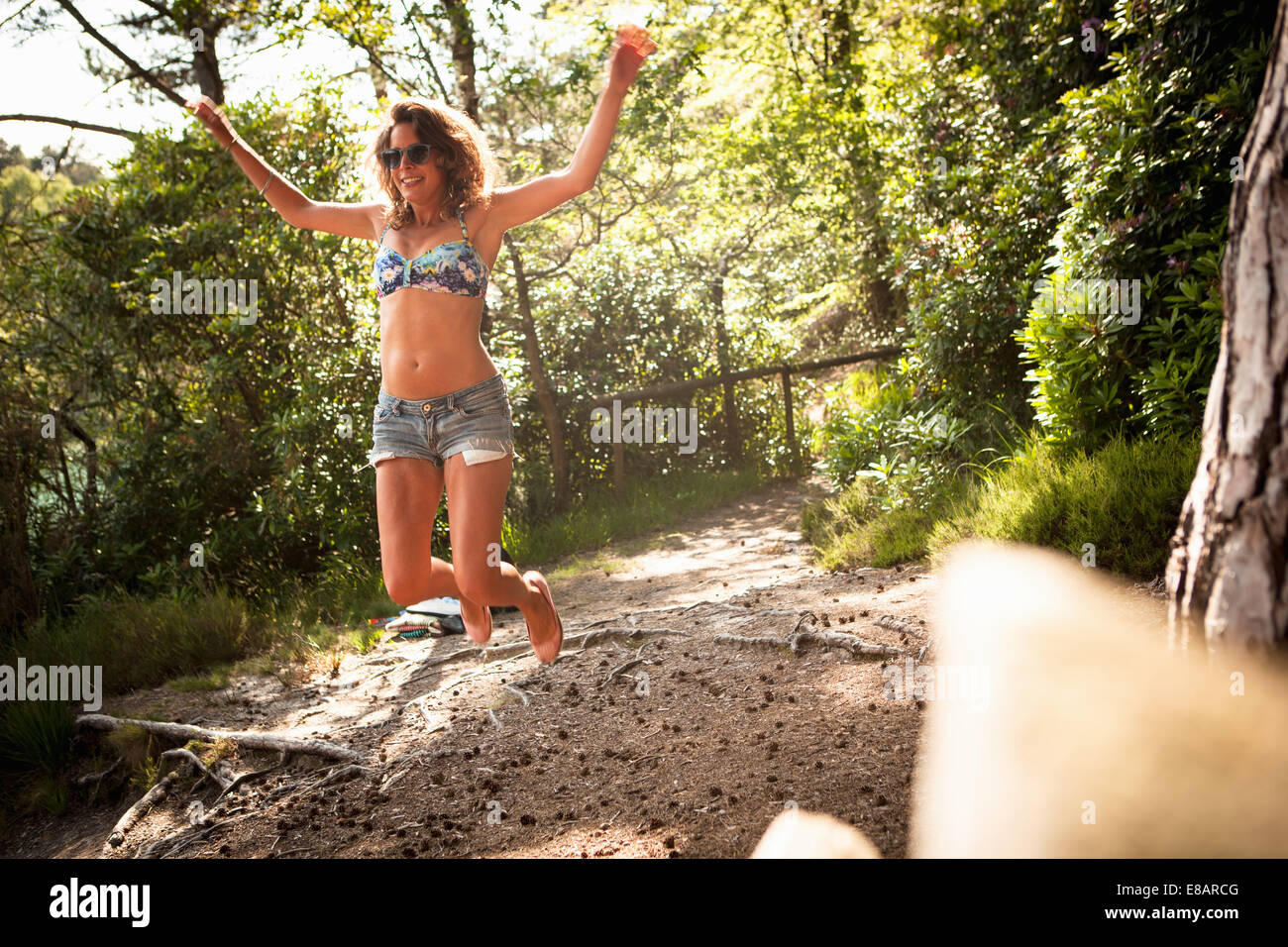 Femme sautant dans les airs, la piscine bleue, Wareham, Dorset, Royaume-Uni Banque D'Images