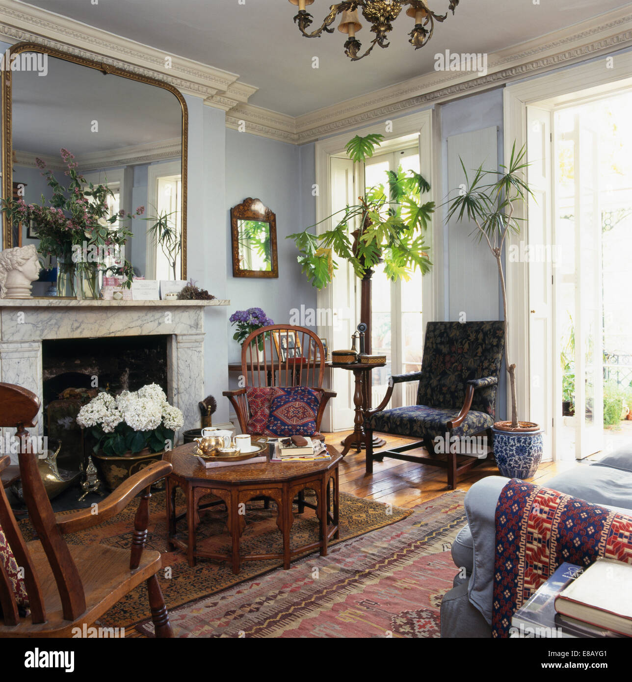 Grand miroir au-dessus de la cheminée de marbre gris pâle au salon avec des plantes vertes Banque D'Images