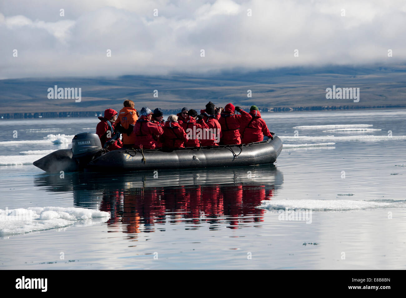 Zodia plein d'éco-touristes, avec la réflexion, l'île de Baffin, au Canada, l'océan Arctique. Banque D'Images