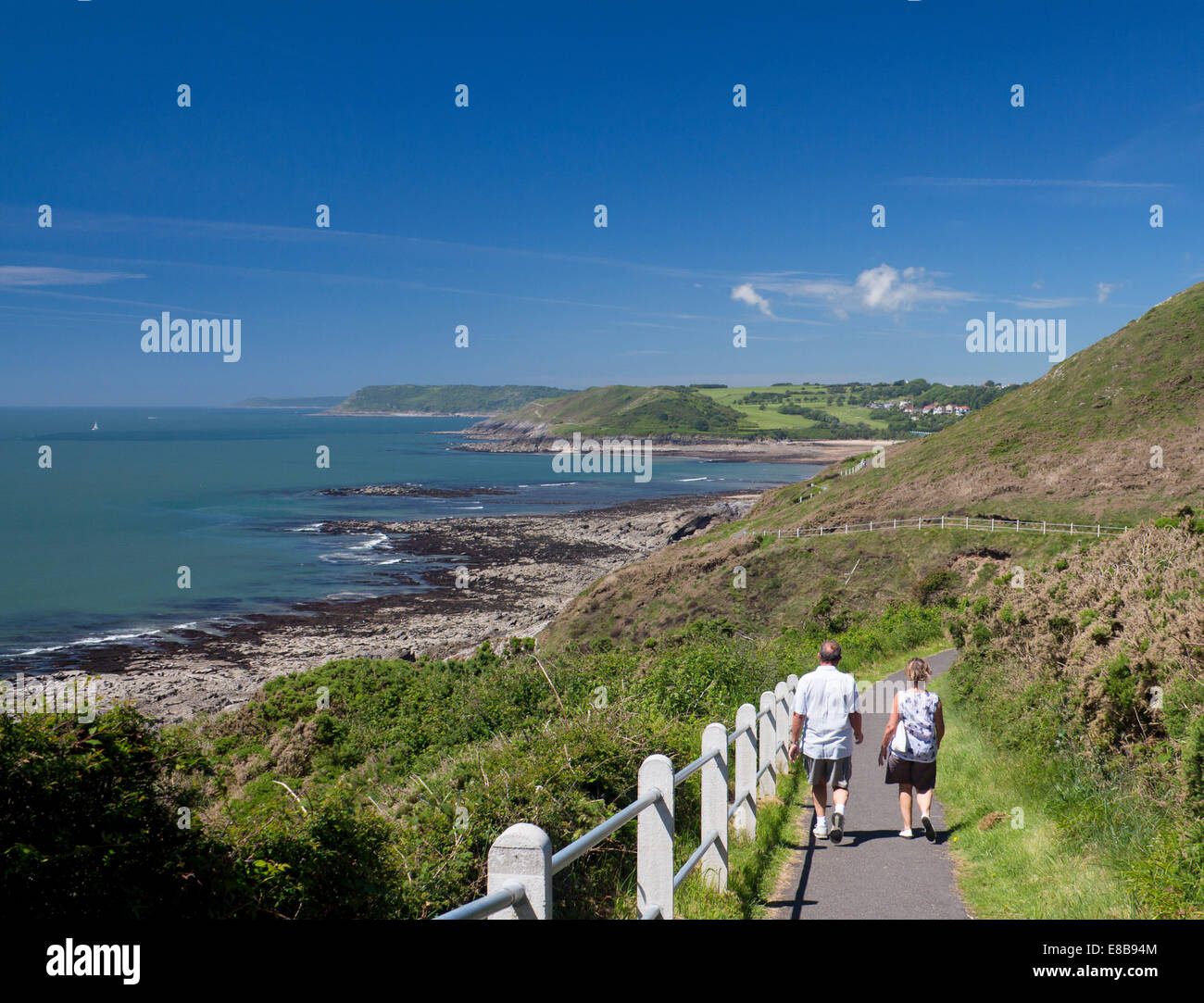 Couple en train de marcher sur la section de voie entre la côte du Pays de Galles Mumbles et Langland Bay, à l'ouest de la péninsule de Gower Swansea Wales UK Banque D'Images