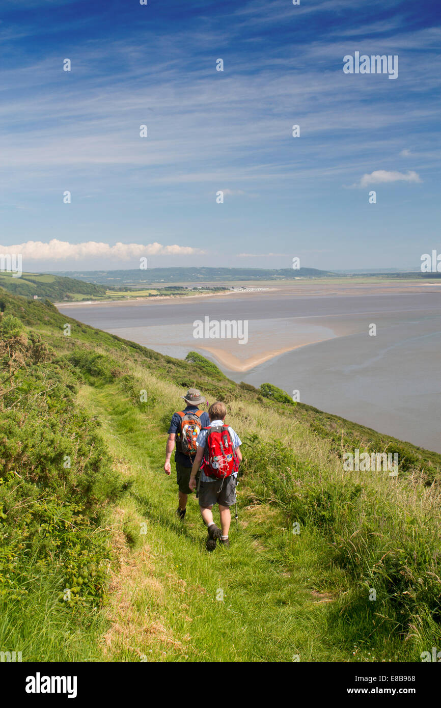 Couple en train de marcher sur le chemin de la côte du Pays de Galles sur Point Wharley pointe au-dessus de l'estuaire et Tywi Towy Carmarthen Bay South Wales UK Banque D'Images