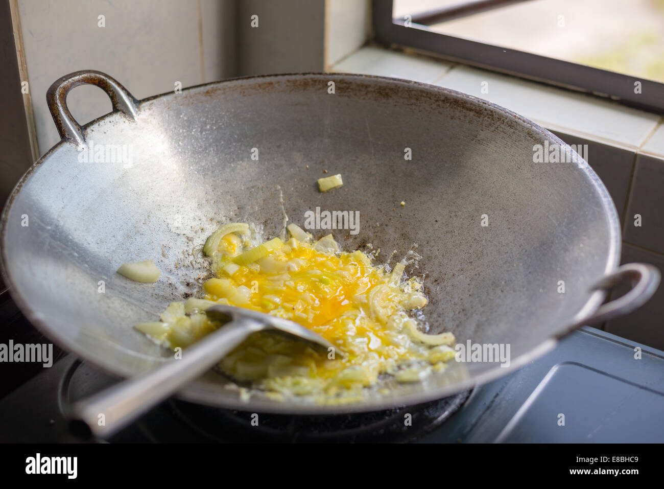 Style asiatique et les oignons oeufs sautés dans un wok cuisson Banque D'Images