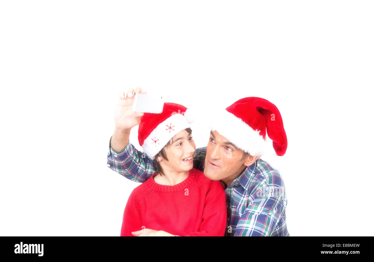 Père et fils s'amusant faisant un selfies pour Noël. Isolé sur blanc. Banque D'Images