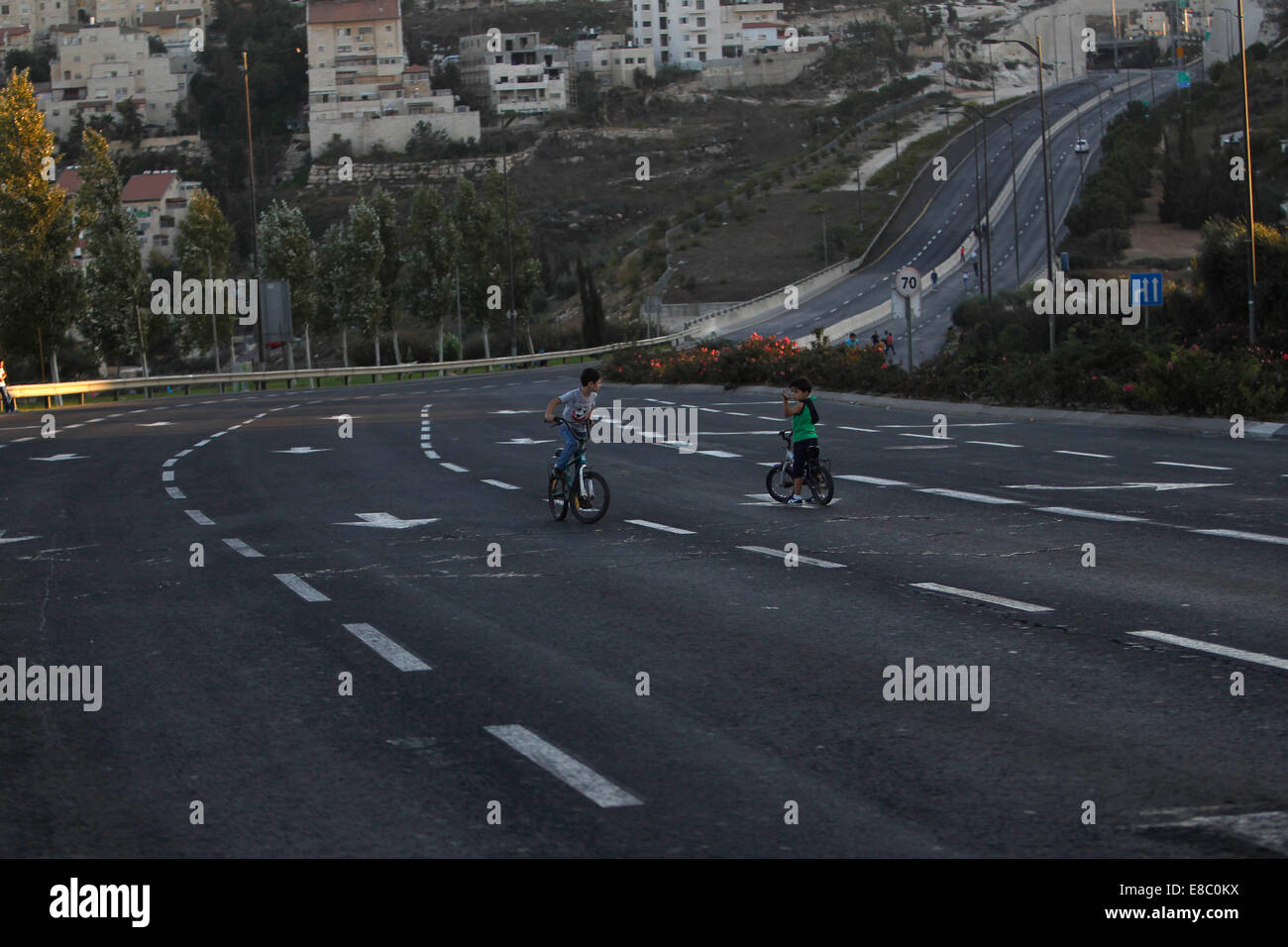 Jérusalem. 4ème Oct, 2014. Deux garçons de la bicyclette sur une autoroute vide à Jérusalem pendant les fêtes juives de Yom Kippour le Oct 4, 2014. Yom Kippour, jour des Expiations juif, est un jour solennel de réflexion et de jeûne, sur lequel la plupart des automobiles ne sont pas autorisés sur les routes. © Muammar Awad/Xinhua/Alamy Live News Banque D'Images