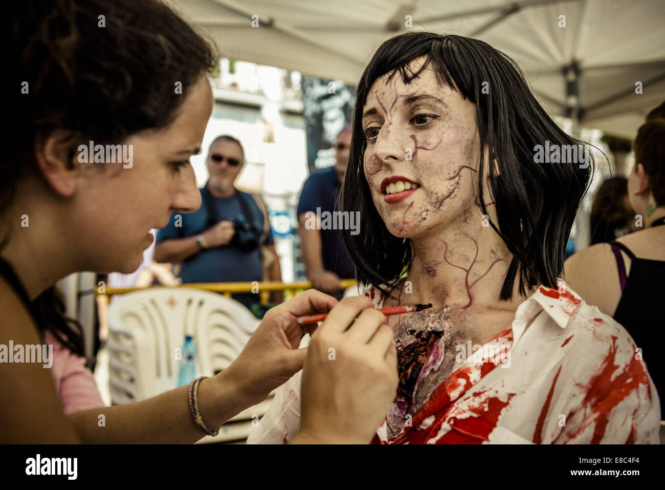 Sitges, Espagne. 4ème Oct, 2014. Maquilleuse met un maquillage zombie sur le cou d'une femme pour l'Sitges Zombie Walk 2014 Credit : Matthias Rickenbach/ZUMA/ZUMAPRESS.com/Alamy fil Live News Banque D'Images