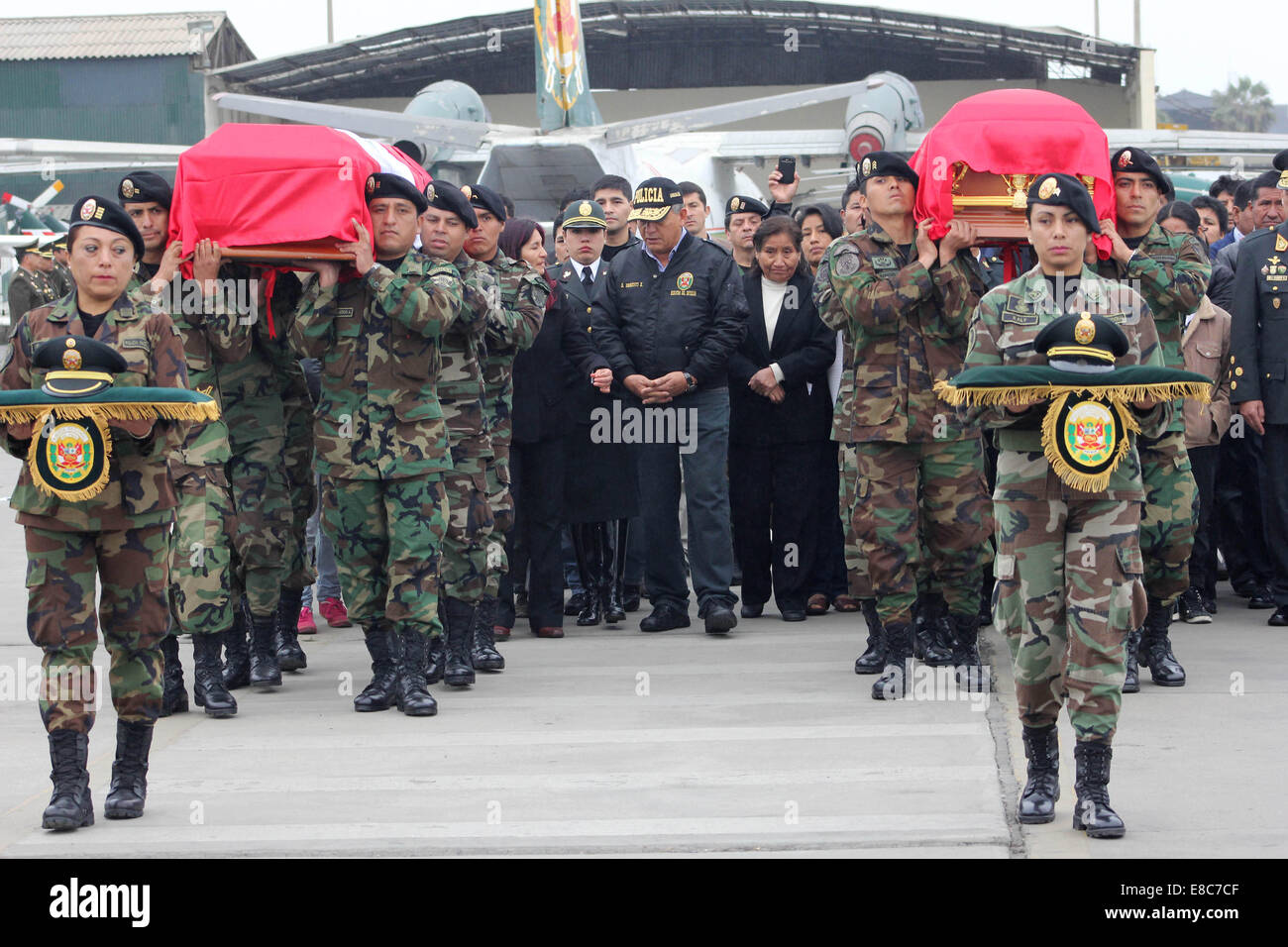 Callao, Pérou. 4ème Oct, 2014. Le ministre de l'intérieur du Pérou, Daniel Urresti (C), accompagne les proches des policiers tués lors d'une attaque contre un convoi, à leur arrivée à la base de la Direction de la police de l'air, dans la province de Callao Costitutional, département de Lima, Pérou, le 4 octobre 2014. Le vendredi, un convoi de la Police nationale a été attaqué tout en se gardant le transfert de matériel électoral à Ayacucho, laissant deux morts et cinq policiers blessés, selon la presse locale. Crédit : Luis Camacho/Xinhua/Alamy Live News Banque D'Images