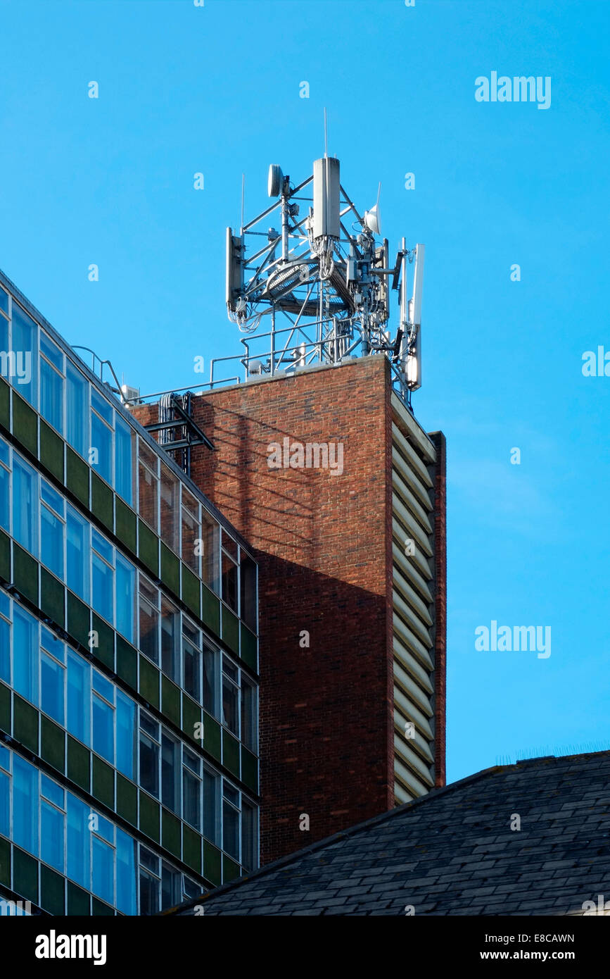 Téléphone mobile et l'équipement de télécommunications monté sur le haut d'un immeuble du centre-ville angleterre uk Banque D'Images