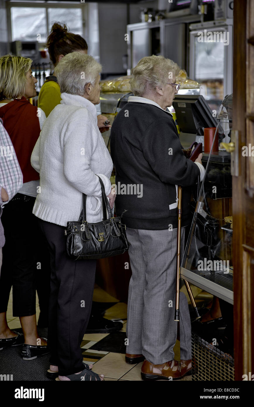 Les femmes âgées ont fait la queue dans un comptoir-boutique. Angleterre Royaume-Uni Banque D'Images
