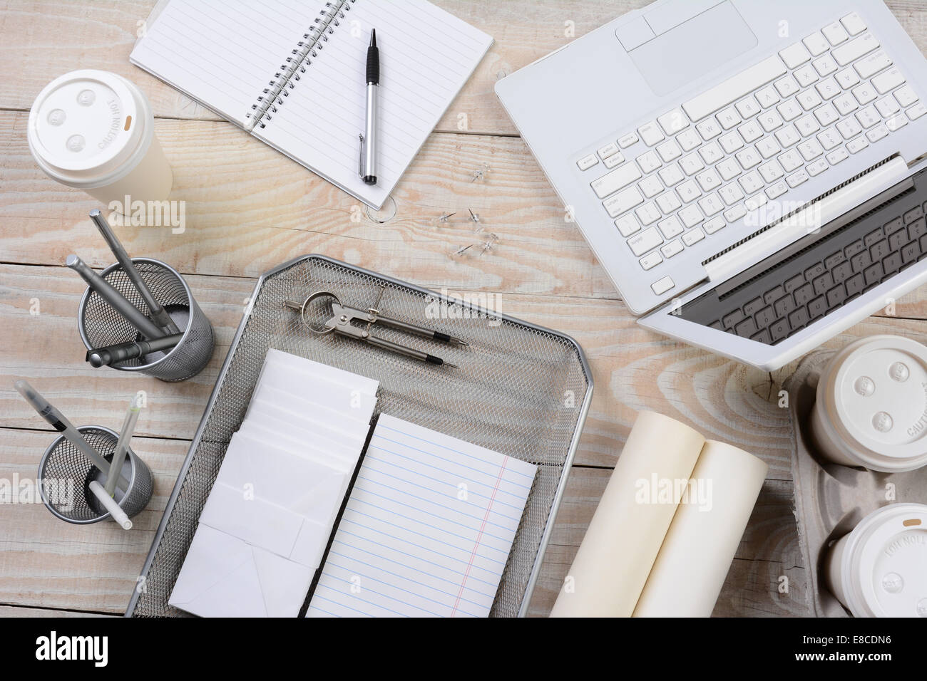 High angle shot d'un bureau à la maison Bureau à différents articles y compris : un ordinateur portable, des tasses à café, pad, ordinateur portable, stylos, crayon cu Banque D'Images