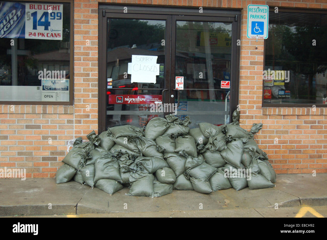 Cette photographie montre des sacs de sable placés autour d'une station-service à Cedar Rapids, dans l'Iowa. Les sacs de sable sont couramment utilisés dans les efforts de prévention des inondations pour protéger les bâtiments et les infrastructures contre les dommages causés par les eaux lors de fortes pluies ou d'inondations. L'image met l'accent sur les mesures locales de préparation à la gestion des inondations dans la région. Banque D'Images